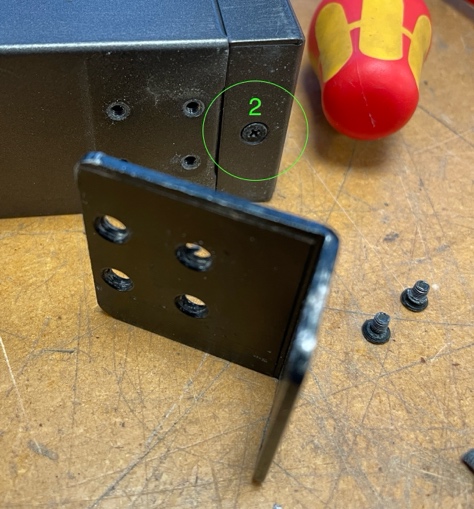 A screwdriver and screws on a table Description automatically generated